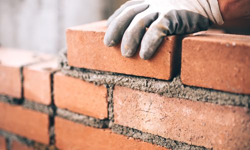 Close,Up,Of,Industrial,Bricklayer,Installing,Bricks,On,Construction,Site